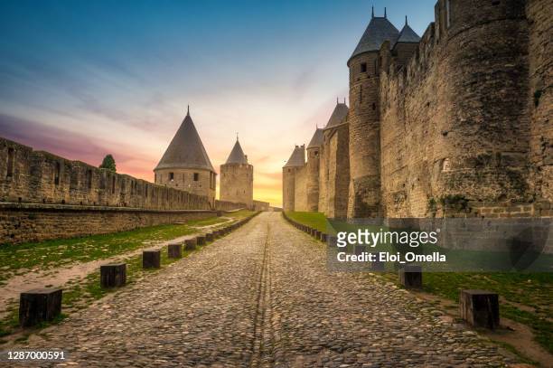 walls of carcassonne at sunrise - carcassonne imagens e fotografias de stock