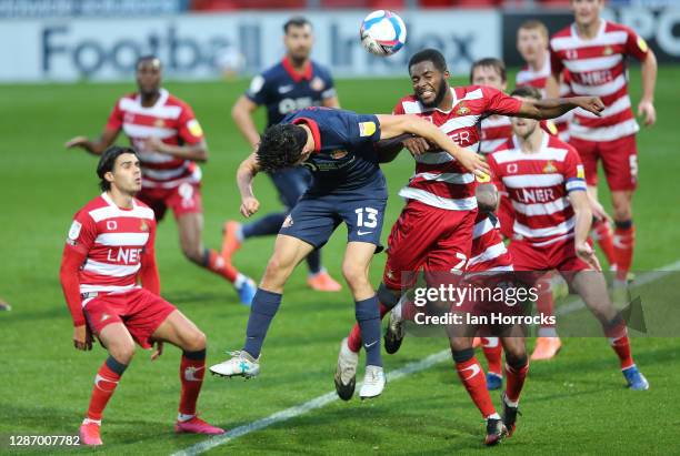 Luke O'Nien of sunderland goes for a header with Cameron John of Doncaster during the Sky Bet League One match between Doncaster Rovers and...