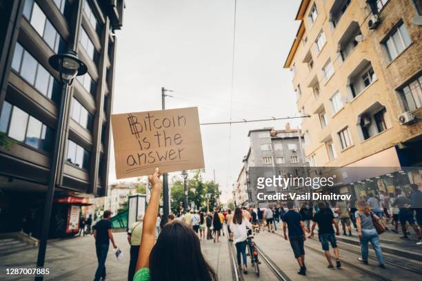 young woman holding a poster against corruption. human rights and democracy concept. strike / protest in the city concept. - scarce imagens e fotografias de stock