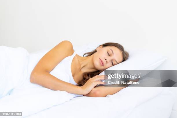 Side view waist portrait of beautiful sleeping woman in bed. Female with long hair resting