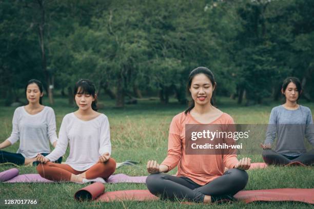 chinese young women practicing yoga at public park - spiritual enlightenment stock pictures, royalty-free photos & images