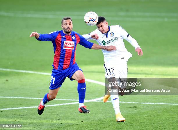 Pedro Leon of Eibar challenges for the high ball with Mathias Olivera of Getafe during the La Liga Santander match between SD Eibar and Getafe CF at...