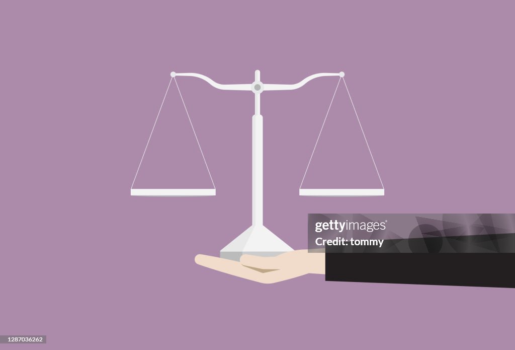 Mano sosteniendo un equilibrio de igual brazo