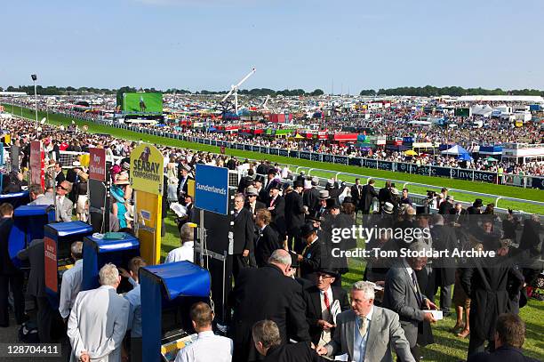 Racegoers enjoy the betting and the atmosphere at the Investec Derby Day held at Epsom Downs Racecourse, Surrey, southern England. The Queen's horse...