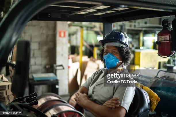 Portrait of a senior woman driving a forklift in an industry