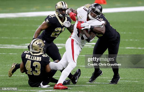 Julio Jones of the Atlanta Falcons is tackled by Demario Davis,Marcus Williams and Patrick Robinson of the New Orleans Saints in the first quarter at...