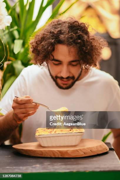young man eating mac and cheese - mac and cheese stock pictures, royalty-free photos & images