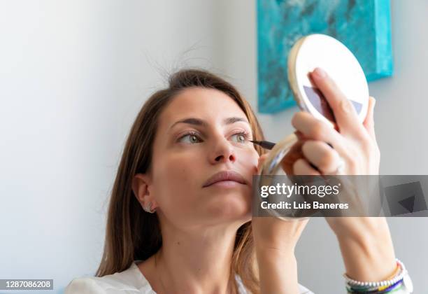 woman doing makeup of eyes at home - eyeliner ストックフォトと画像