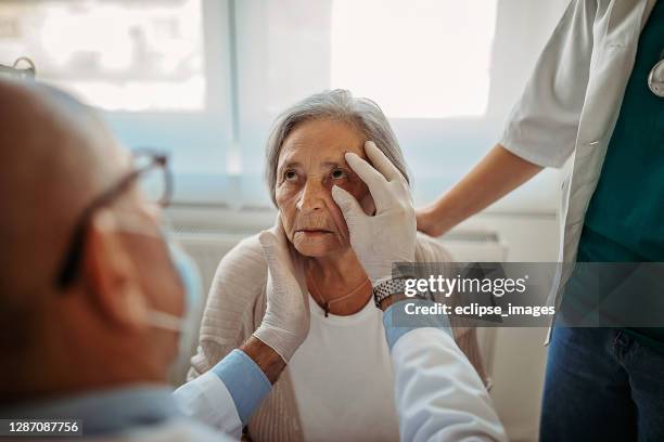 arzt führt eine augenuntersuchung des patienten durch - optical art stock-fotos und bilder