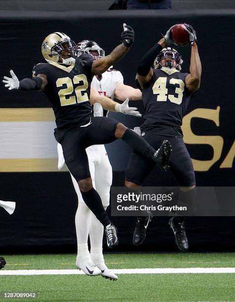 Marcus Williams of the New Orleans Saints intercepts a pass in the end zone from Matt Ryan of the Atlanta Falcons as teammate Chauncey...