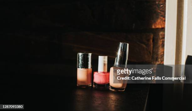 variations of pink nail polish on a black surface against an exposed brick wall - combinação cor de pele imagens e fotografias de stock