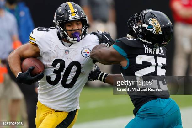 James Conner of the Pittsburgh Steelers stiff arms D.J. Hayden of the Jacksonville Jaguars during the second half at TIAA Bank Field on November 22,...