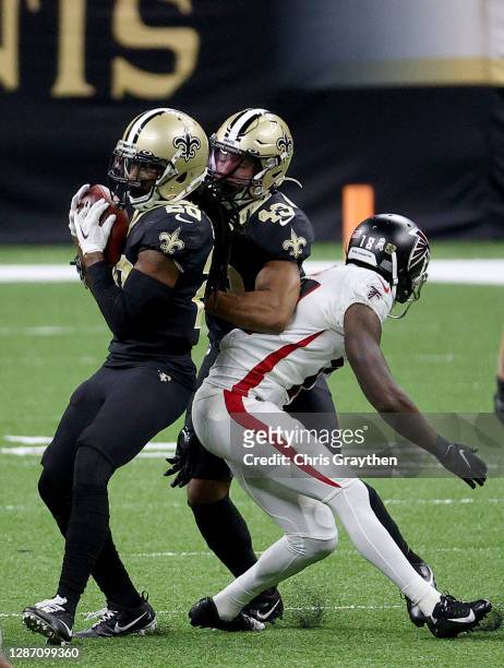 Janoris Jenkins of the New Orleans Saints intercepts a pass intended for Calvin Ridley of the Atlanta Falcons as Marcus Williams of the New Orleans...
