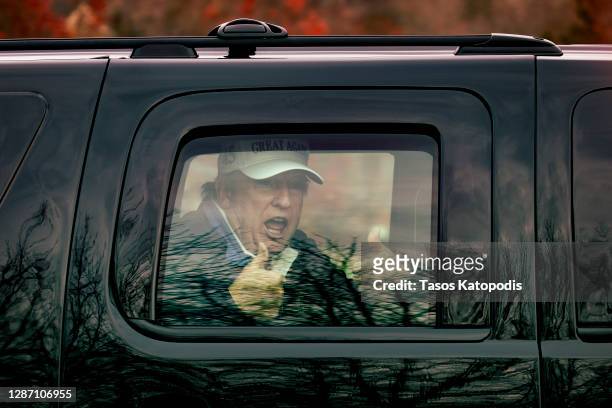 President Donald Trump gives thumbs up to supporters from this motorcade after he golfed at Trump National Golf Club on November 22, 2020 in...
