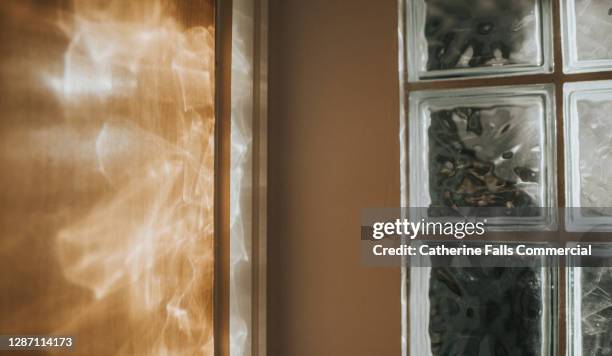 glass bricks creating lighting effect against a wall - reflector stock-fotos und bilder