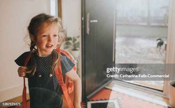 happy little girl wears a backpack in a sunny environment - first day of school bildbanksfoton och bilder
