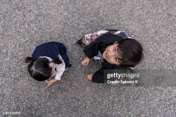 little boy in 'hakama' and his sister playing with gravels - shichi go san stock pictures, royalty-free photos & images