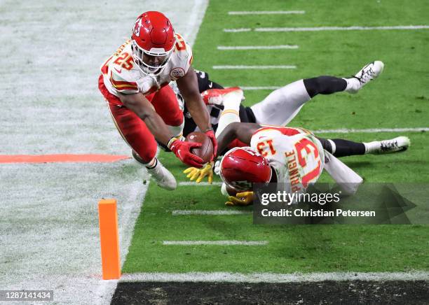 Running back Clyde Edwards-Helaire of the Kansas City Chiefs dives into the end zone for a touchdown past the defense of strong safety Jeff Heath of...