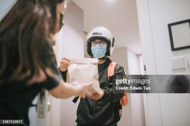 asiático chino repartidor con casco y máscara quirúrgica prensa campana de la puerta para la entrega de alimentos de supermercado - door bell fotografías e imágenes de stock