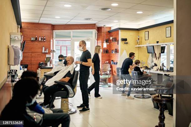 busy modern hair salon in time of covid-19 - busy barber shop stock pictures, royalty-free photos & images