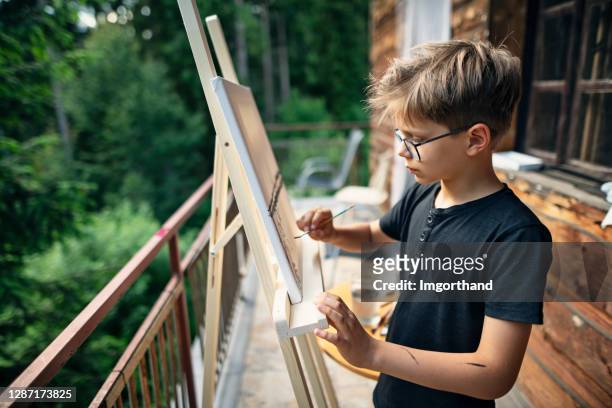weinig jongen die op schildersezel schildert - child art stockfoto's en -beelden