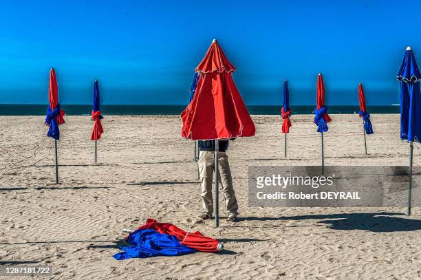 Un employé installe les parasols cabines sur la plage, le 15 avril 2014, à Deauville, France.