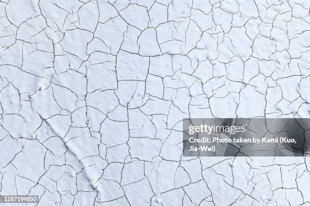 dry cracked white paint wall - cracked stock-fotos und bilder