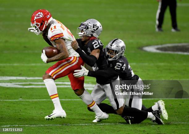 Wide receiver Demarcus Robinson of the Kansas City Chiefs is brought down by cornerback Damon Arnette and strong safety Johnathan Abram of the Las...
