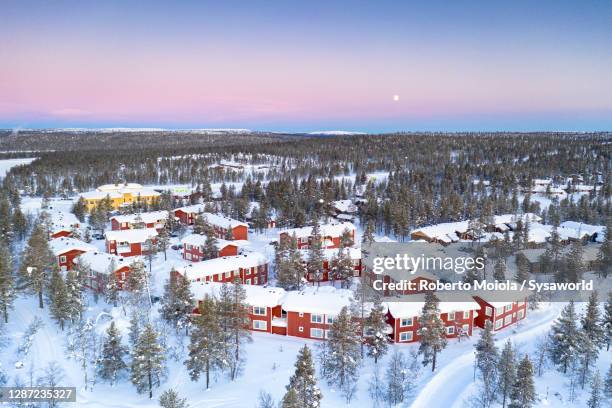 arctic sunrise on snowy forest and tourist resort huts, lapland - saariselka stock pictures, royalty-free photos & images