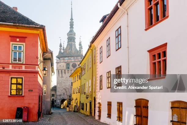 street in sighisoara with old medieval clock tower, transylvania, romania - transylvania romania stock pictures, royalty-free photos & images