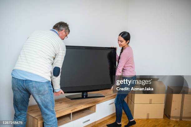 father and daughter carrying the tv into new apartment - carrying tv stock pictures, royalty-free photos & images