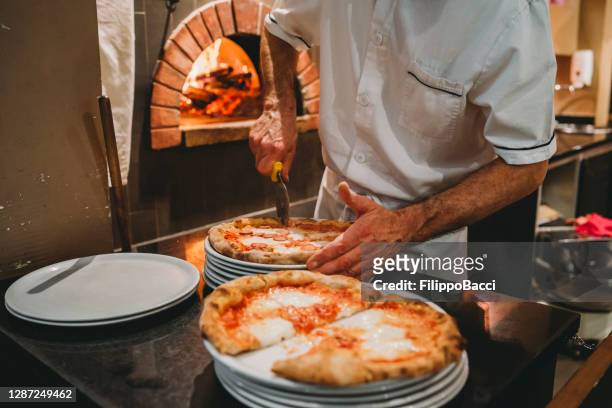 pizzakock som lagar pizza på restaurangen - pizzeria bildbanksfoton och bilder