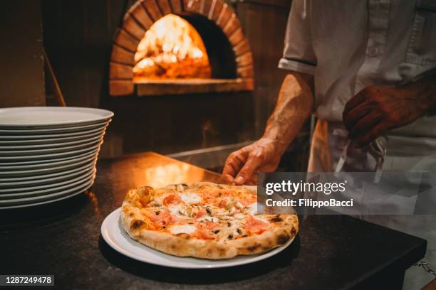 pizza chef preparing pizza at the restaurant - pizza restaurant stock pictures, royalty-free photos & images