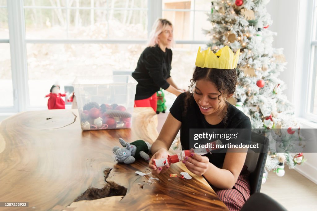 Mixed-race mother and daughter decorating the Christmas tree.