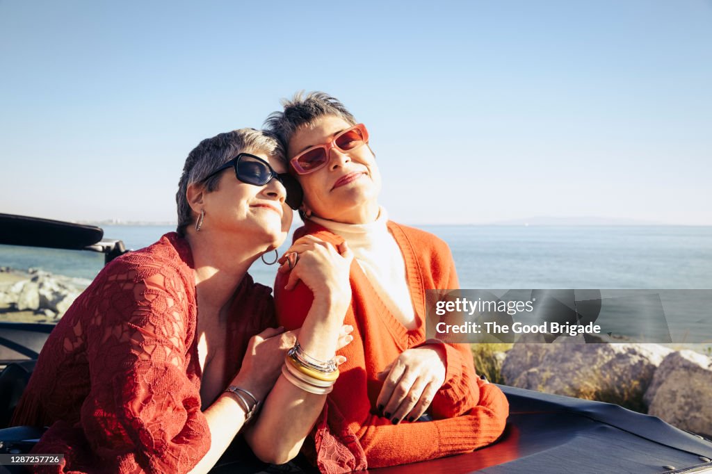 Mature women posing for a photo by the sea