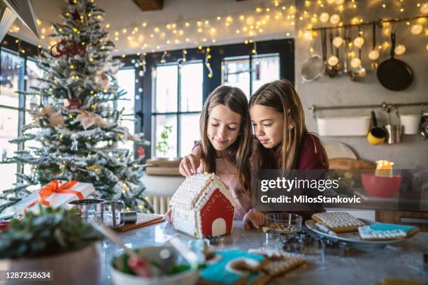 mädchen schmücken lebkuchenhaus - gingerbread house stock-fotos und bilder