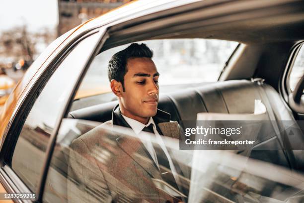 bedrijfsmens die de krant op de taxi leest - newspaper luxury stockfoto's en -beelden