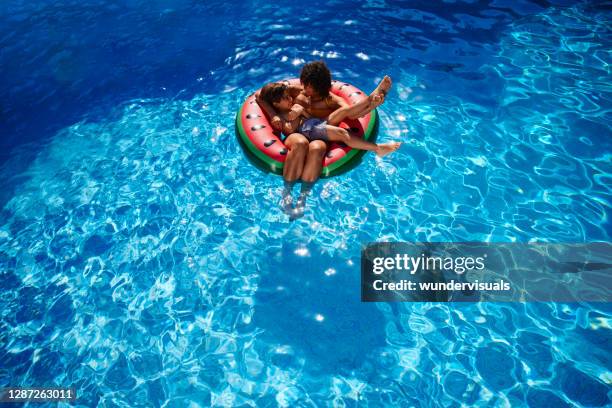 moeder en zoon die in zwemring in een pool drijven - family holidays hotel stockfoto's en -beelden