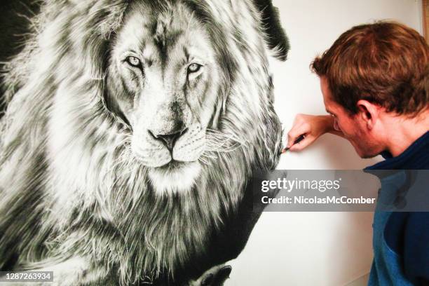 male artist drawing a lion with a charcoal pencil - artists with animals stock pictures, royalty-free photos & images