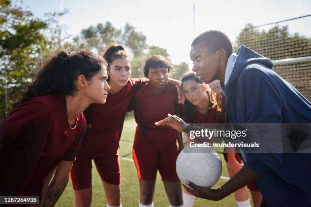 fußballerinnen hören ihrem trainer vor dem spiel zu - team huddle stock-fotos und bilder