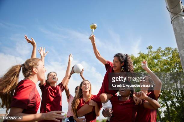 gruppo di giocatrici di calcio che festeggiano la vittoria del gioco con il trofeo - the championship lega di calcio foto e immagini stock
