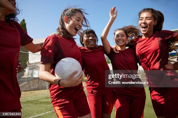 group of soccer players celebrating huddled in circle - time de futebol imagens e fotografias de stock