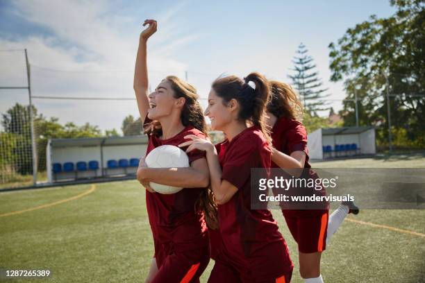 fußballerin läuft mit teamkollegen nach tor - woman football stock-fotos und bilder
