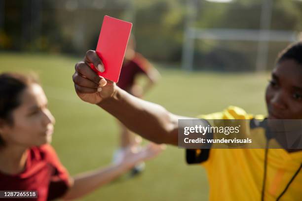 female referee holding red card to soccer player - referee stock pictures, royalty-free photos & images