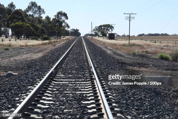 empty railroad tracks against clear sky,nelson st,nhill vic,australia - james popple stock pictures, royalty-free photos & images