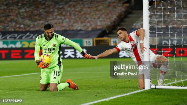 Rui Patricio of Wolverhampton Wanderers collects the ball as Che Adams of Southampton falls into the net during the Premier League match between...