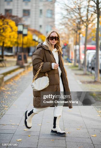 Sonia Lyson is seen wearing two tone creme white black Tire Boots Bottega Veneta, brown down feather puffer coat Arket, hoody and jogger pants Ugg,...