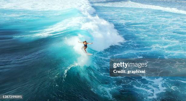 surfer frau reiten auf dem blauen ozean - surfen stock-fotos und bilder