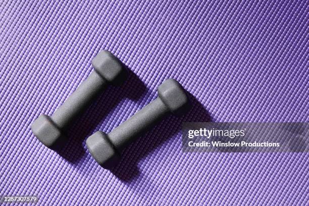 close up of weights on yoga mat - mat stock-fotos und bilder