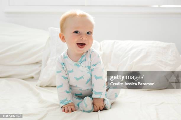 baby boy (6-11 months) lying on bed - baby clothes stock pictures, royalty-free photos & images